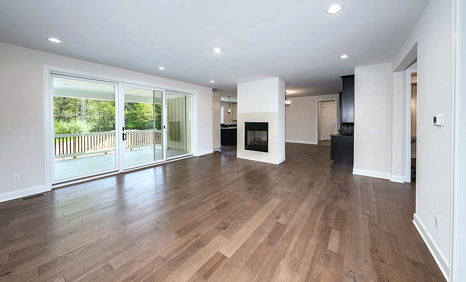 Great room with fireplace and sliding glass doors in a recently completed Kensington home